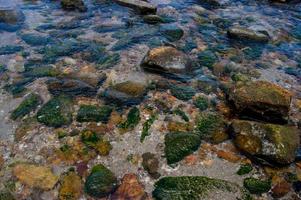 beaux rochers en bord de mer et eau de mer brillante photo