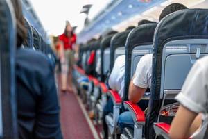 sièges dans l'avion et passagers assis dans toute la zone attendant que l'avion décolle de la piste. photo