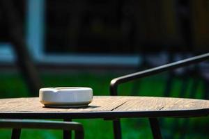 seulement 1 cendrier blanc sur la table en bois sombre dans l'environnement sombre photo