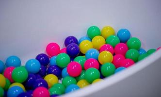 de nombreuses boules colorées sont dans le bain d'eau blanche. photo