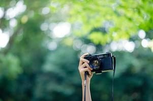 photographe et amateur d'appareil photo appareil photo noir et fond vert naturel