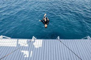 l'homme asiatique fait un saut périlleux dans la mer photo