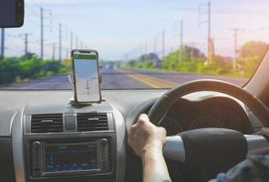 conducteur de voiture utilisant un smartphone avec application de navigation par carte gps tout en conduisant sur l'autoroute, vue depuis l'intérieur de la voiture photo