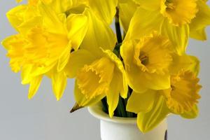 un bouquet de jonquilles dorées dans un vase en céramique décoré photo