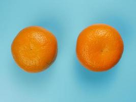 concept créatif à base d'oranges sur fond bleu pastel. concept de fruits sains et minimes photo