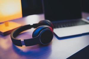 casque sur la table du home studio pour l'enregistrement et ordinateur portable utilisant un logiciel d'enregistrement pour faire de la musique veilleuse. concept de production musicale. photo