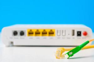 câbles à fibres optiques et réseau avec routeur sans fil internet sur fond bleu photo