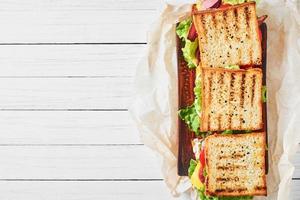trois sandwichs au jambon, laitue et légumes frais sur fond blanc, vue de dessus avec espace de copie photo