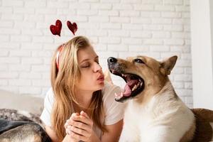 jeune femme avec son mignon berger à la maison s'amusant et s'embrassant photo