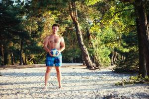 jeune homme jouant au volley-ball sur la plage photo