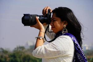 image de photographe féminin portrait d'un photographe couvrant son visage avec l'appareil photo. photo