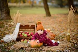 petite fille s'appuie sur une citrouille. photo