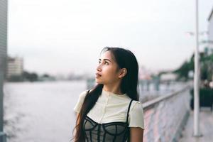 jeune femme adulte asiatique célibataire debout à l'embarcadère des navettes. photo