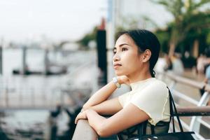 jeune femme adulte asiatique célibataire debout à l'embarcadère des navettes. photo