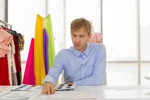 Les concepteurs de couture masculins professionnels au bureau ont une variété de combinaisons de couleurs de tissu. photo