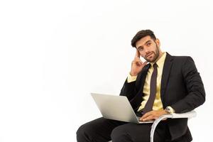 un bel homme d'affaires assis sur une chaise montrant un comportement fantaisiste isolé sur fond blanc, photo