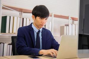 un homme d'affaires assis dans un bureau avec diligence et détermination photo