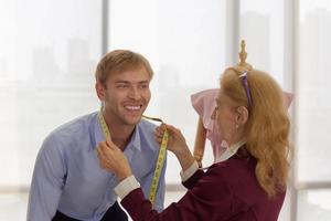 les créatrices professionnelles mesurent la taille des clients masculins qui utilisent le service pour la couture. photo