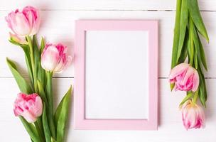 belles tulipes blanches et roses, cadre photo pour texte sur fond en bois blanc.