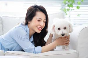 jeune femme asiatique jouant avec un chien à la maison photo