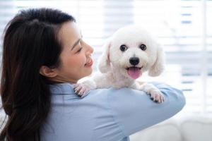 jeune femme asiatique jouant avec un chien à la maison photo