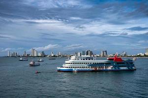 ferry-boat flottant sur la mer tropicale et les bâtiments du centre-ville sur la côte photo