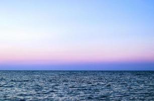 panorama de l'océan bleu avec reflet du soleil, la vaste mer ouverte avec un ciel clair, une vague d'ondulation et une mer calme avec une belle lumière du soleil photo