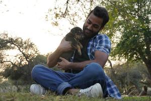 jeune garçon avec un chiot mignon dans le parc photo