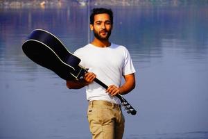 homme jouant de la guitare acoustique sur le bateau. photo