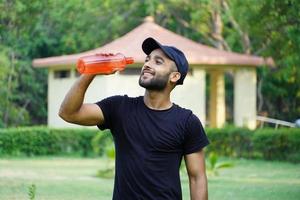 un homme qui boit de l'eau dans le parc photo