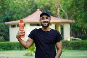 un homme avec une bouteille d'eau dans le parc photo