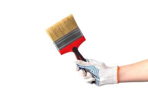 l'homme en gants de travail blancs tient un nouveau pinceau avec une poignée rouge. outil de réparation à la main isolé sur fond blanc. photo