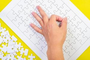 puzzle et mains sur le fond jaune du concept photo