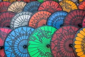 groupe de parasols myanmar colorés vendus dans une boutique de souvenirs. le parasol pathein pour un est tout simplement enchanteur, avec son beau design contenant une sorte de peintures artistiques dessus. photo