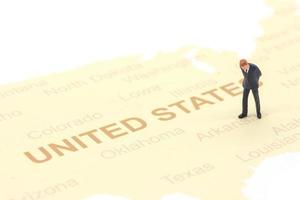 personnes miniatures, homme d'affaires debout sur la carte américaine photo