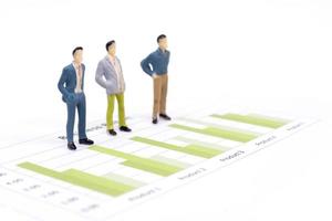 Figures miniatures hommes d'affaires debout sur un graphique graphique financier photo