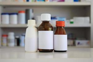 étiquette blanche vierge de flacon de médicament avec des étagères floues de médicament dans l'arrière-plan de la pharmacie de la pharmacie
