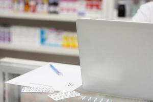 pharmacien avec ordinateur portable et médicaments à la pharmacie photo