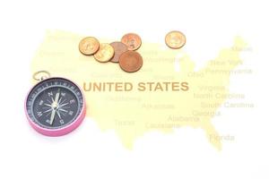 boussole et pièces de monnaie sur une carte américaine. concept de voyage d'affaires photo