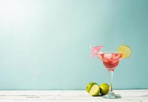 cocktail d'été frais avec fraise, citron vert et glaçons sur fond bleu avec espace de copie photo
