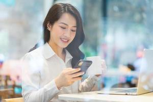 femme d'affaires asiatique travaillant dans un café photo