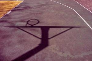 silhouettes sur le terrain de basket de la rue rouge photo