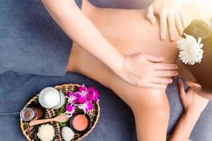 massages et soins du corps. jeune femme bronzée ou peau de miel recevant des épaules relaxantes massant dans une maison de spa. belle femme se faisant masser dans le salon spa pour les soins de beauté. photo