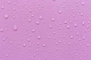 gouttelettes d'eau sur fond rose. comme goutte de fond sur le produit. photo