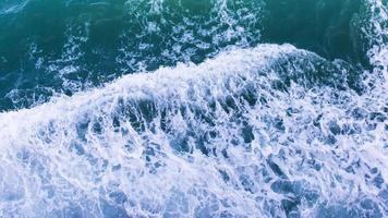 vue de dessus avec des vagues et des bulles de surface de l'eau bleu océan. photo