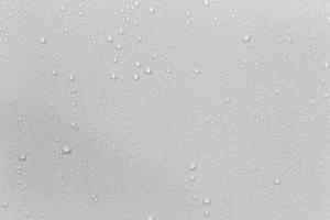 le concept de gouttes de pluie tombant sur un fond gris abstrait surface blanche humide avec des bulles sur la surface réaliste gouttelettes d'eau pure gouttes d'eau pour la conception de bannières créatives photo