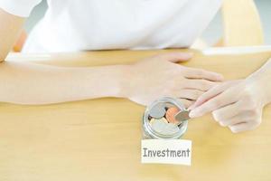 mains de femme avec des pièces de monnaie dans un bocal en verre, vue de dessus photo