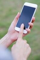 gros plan de la main féminine à l'aide d'un téléphone portable sur fond de ferme photo