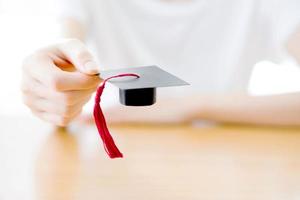 femme tenant une casquette de graduation photo