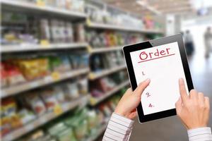 homme utilisant un ipad lors de ses achats au supermarché photo